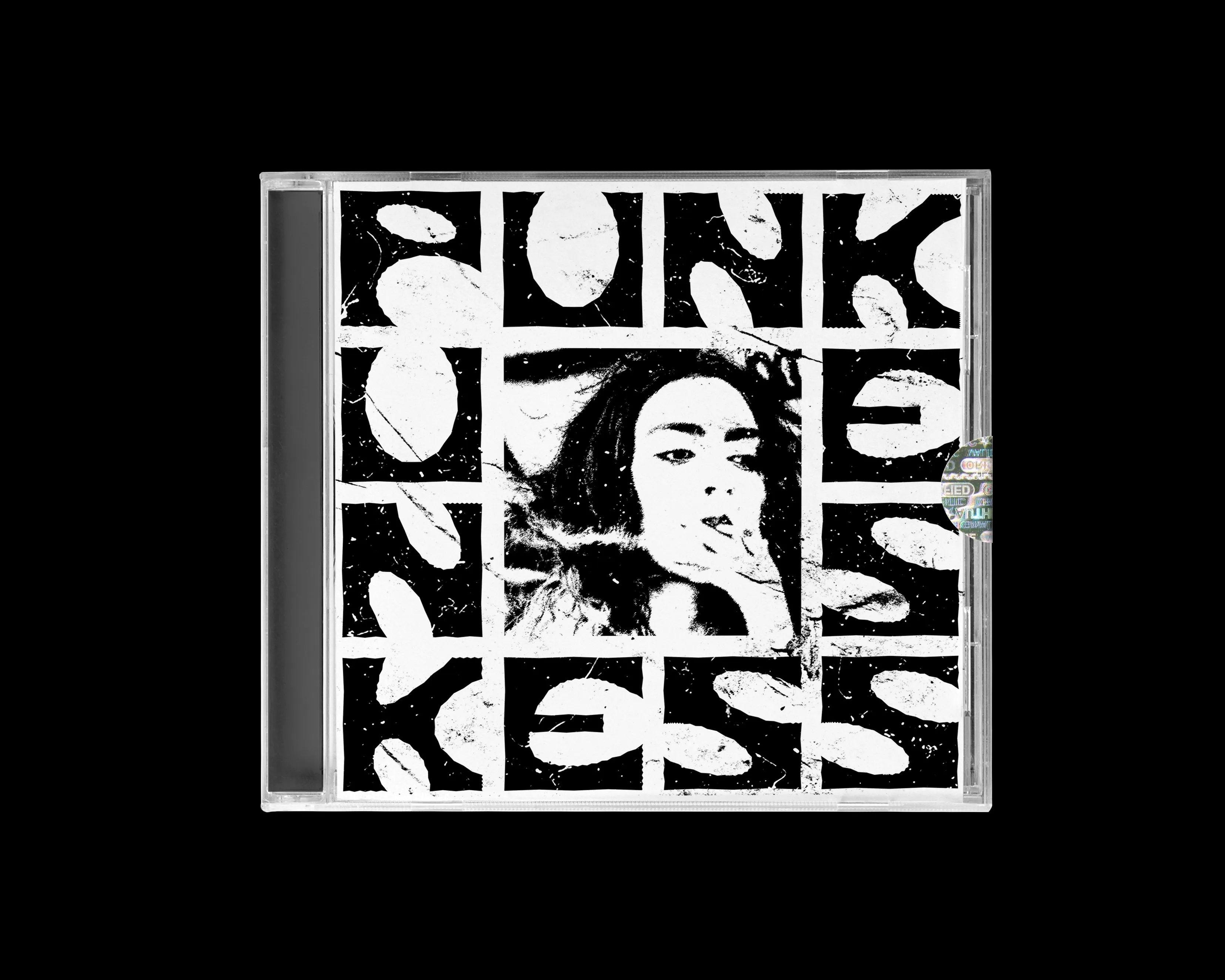 A CD in a jewel case: high-contrast black-and-white lettering in a grid, a cut-out portrait sitting at its centre.
